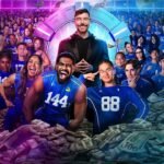MrBeast stands at the center of the Beast Games arena surrounded by hundreds of contestants wearing blue numbered jerseys, with piles of cash and money flying through the air, representing the high-stakes Amazon Prime competition show.